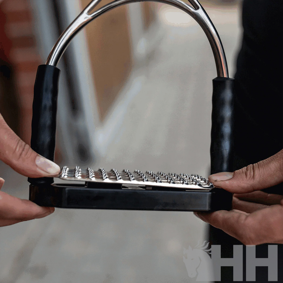 Estribo metálico para cavalo com partes pretas e detalhes metálicos