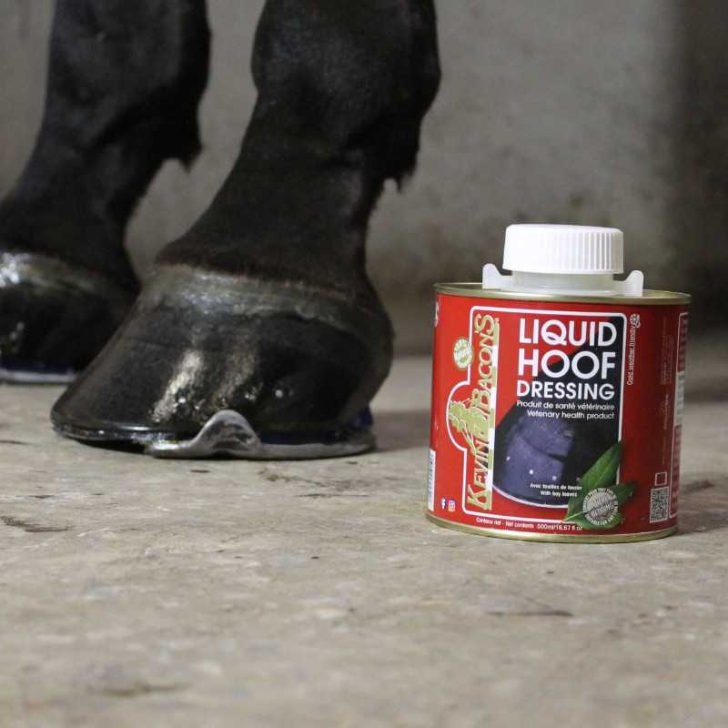 Lata vermelha de produto LIQUID HOOF DRESSING ao lado de casco de cavalo preto no chão do estábulo