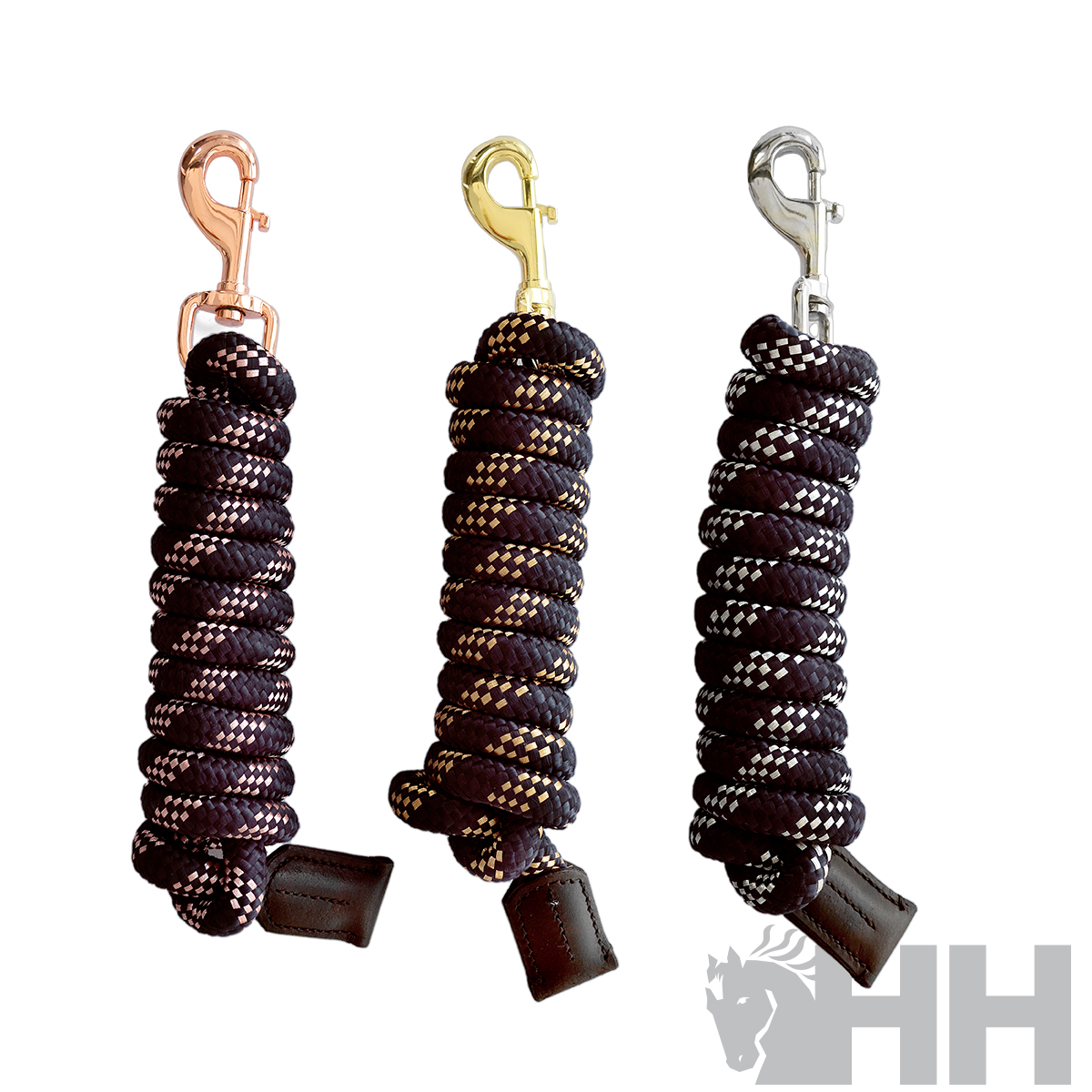 Três cordas pretas para equitação com ganchos metálicos em cobre, dourado e prata sobre fundo branco