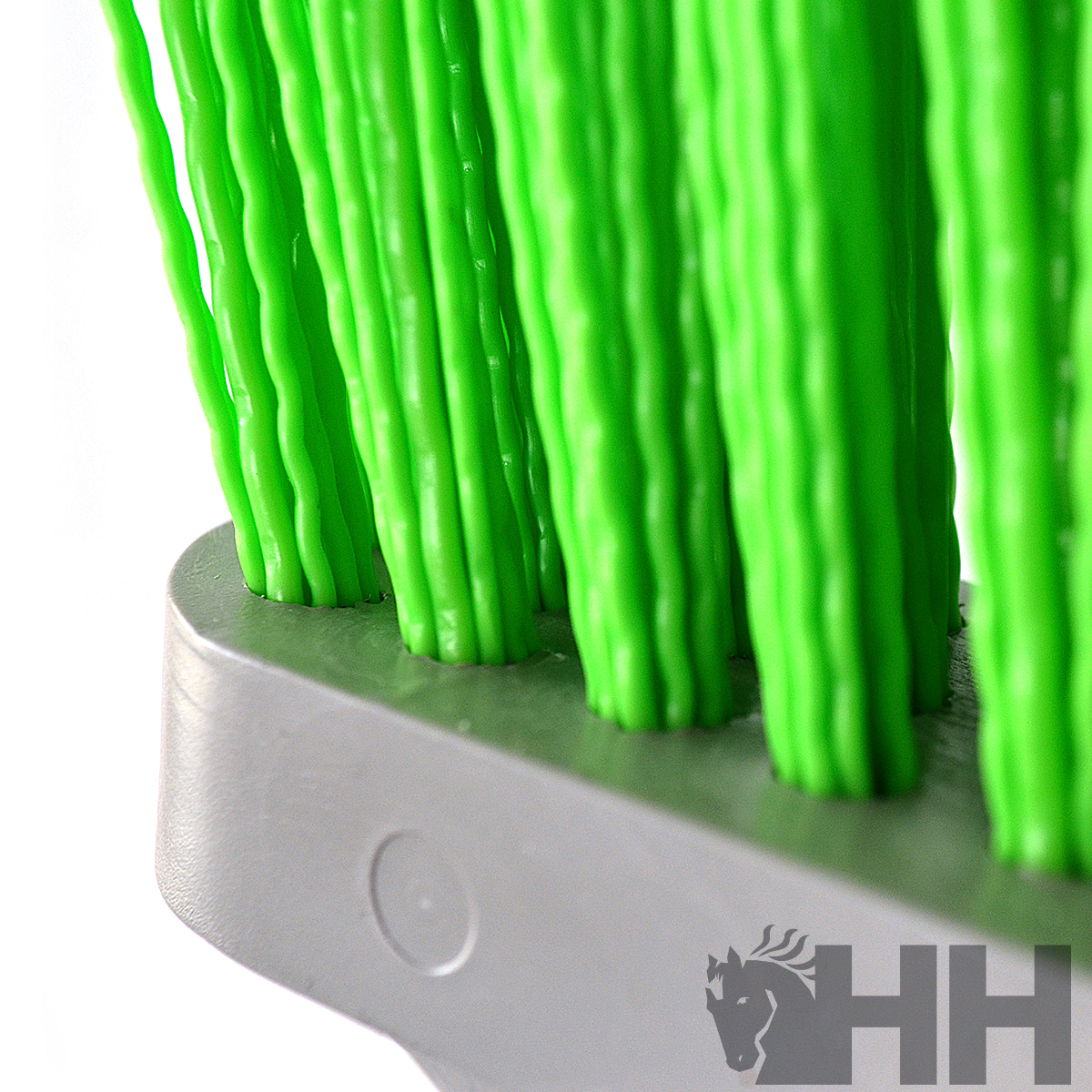Escova com cerdas verdes e base cinzenta em fundo branco, com logótipo HH
