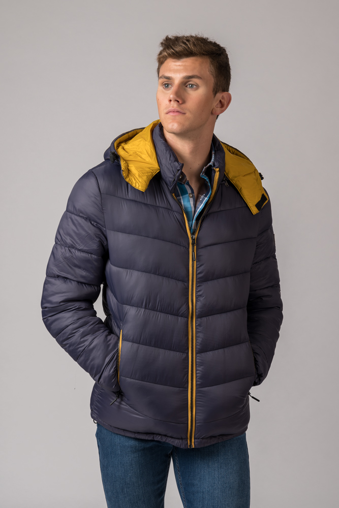 Casaco acolchoado azul escuro com forro amarelo usado por homem