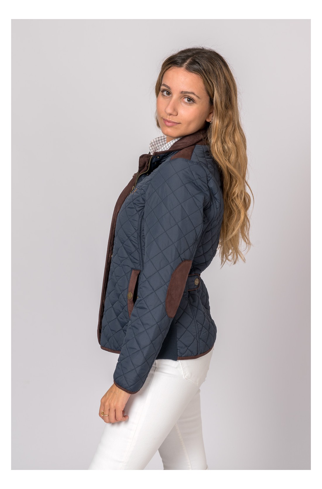 Casaco acolchoado azul escuro com detalhes castanhos em modelo feminino
