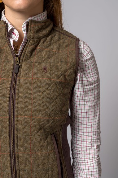 Colete acolchoado castanho com padrão espinha de peixe e camisa quadriculada branca