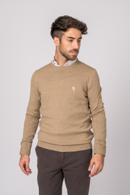 Homem com camisola bege de malha e calças castanhas