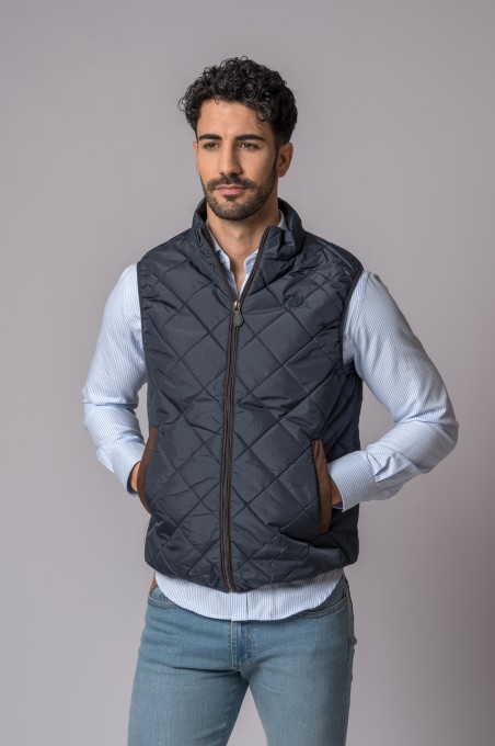 Homem com colete acolchoado azul escuro e camisa azul clara às riscas