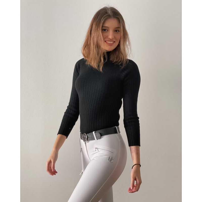 Mulher com camisola preta de malha e calças brancas