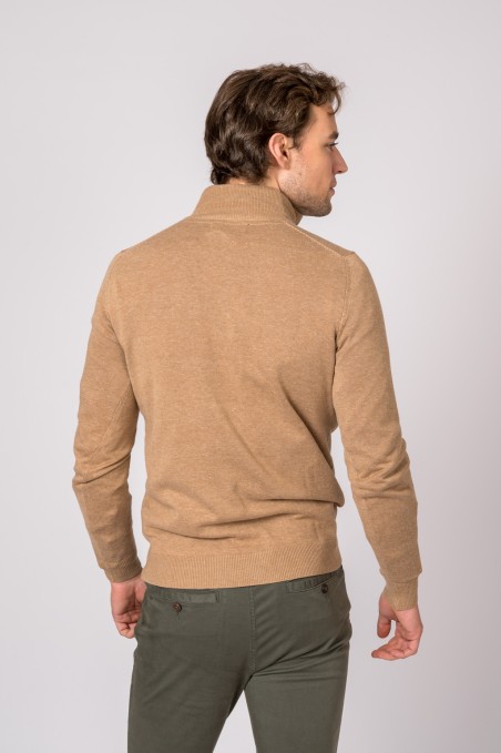 Homem de costas com casaco bege e calças verdes