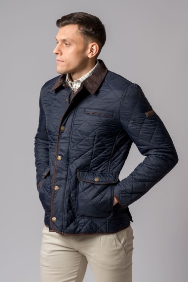 Homem a usar casaco acolchoado azul escuro com gola castanha e bolso exterior
