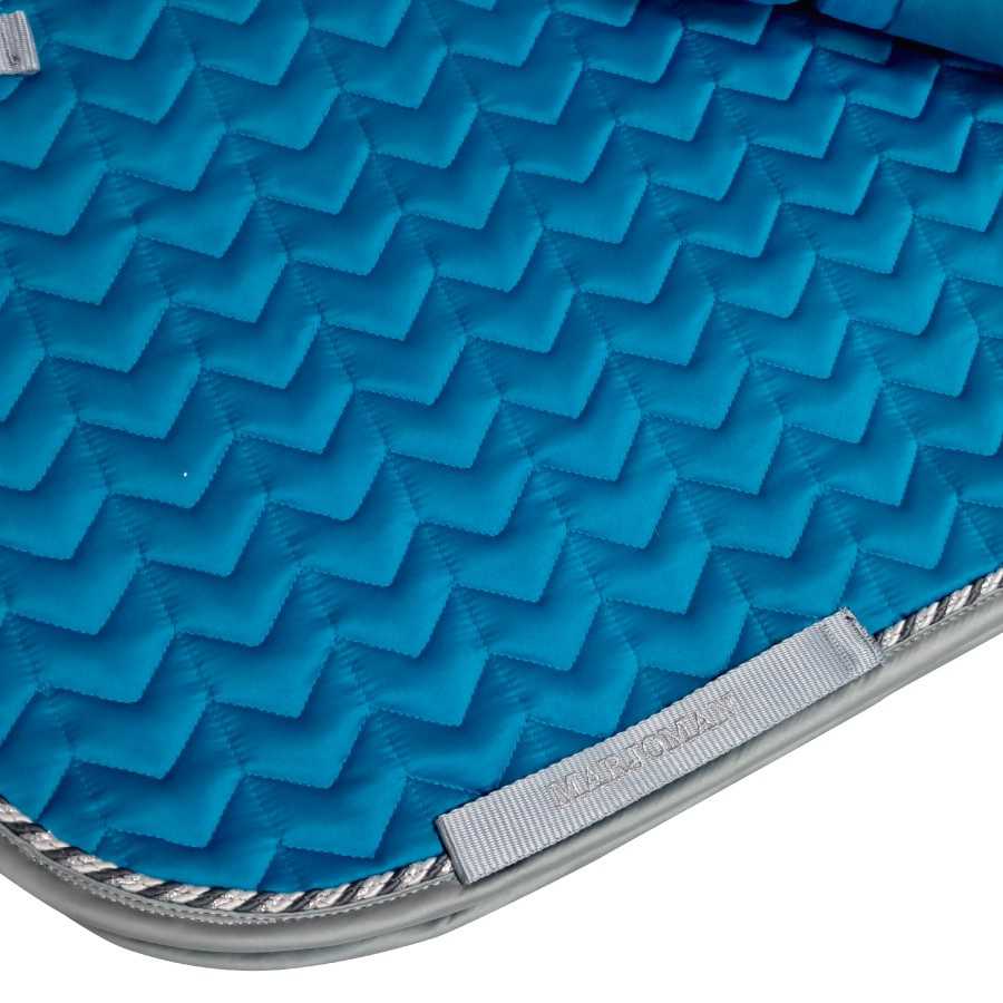 Tapete azul acolchoado com padrão zigzag e bordas arredondadas
