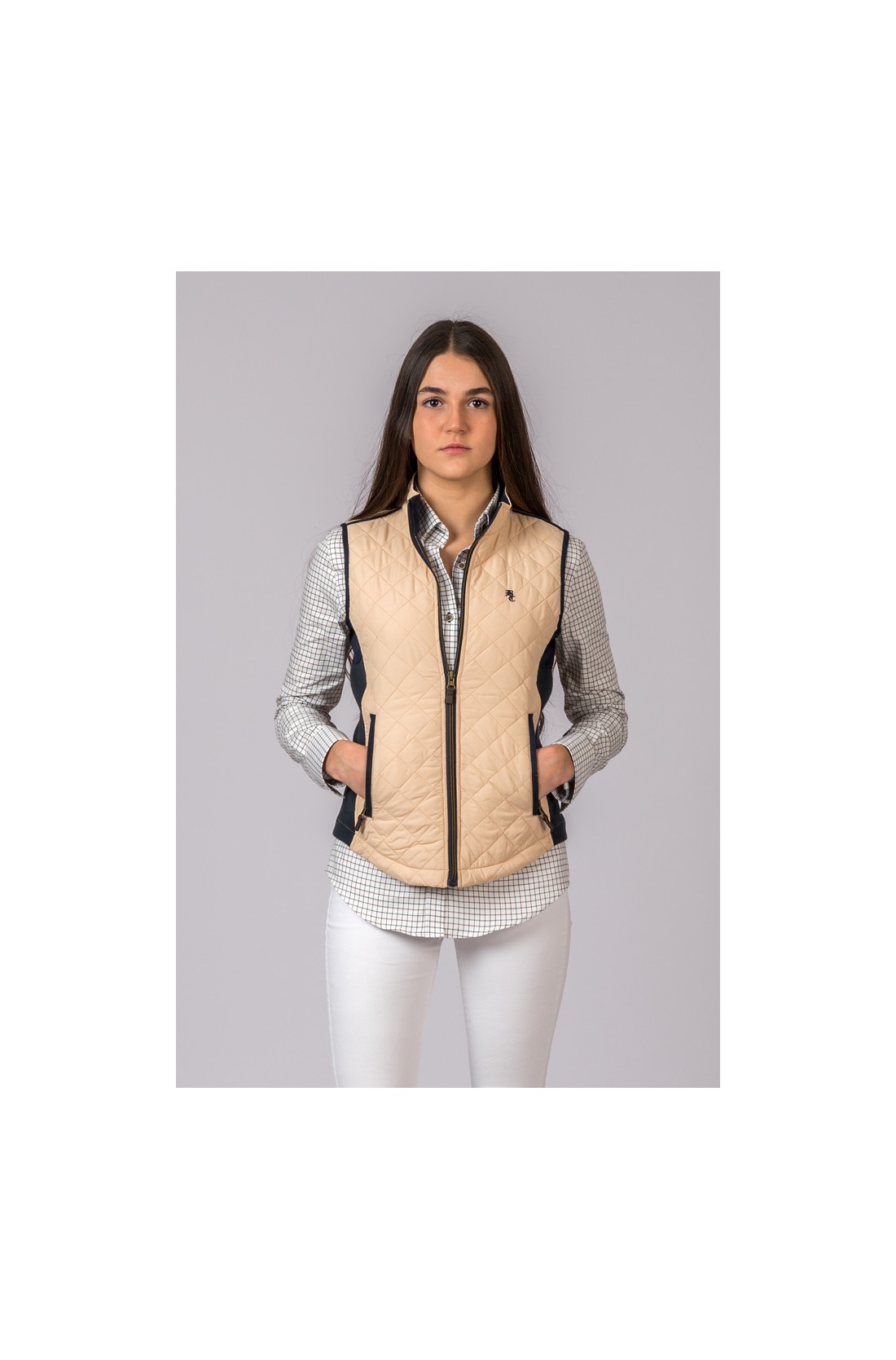 Colete feminino bege acolchoado com fecho de correr preto e camisa branca com padrão de quadrados