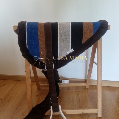 Alforge para cavalo com riscas coloridas e bordas de pêlo pendurado numa estrutura de madeira