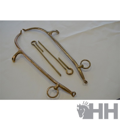 Espora de metal prateado e pinos sobre superfície branca