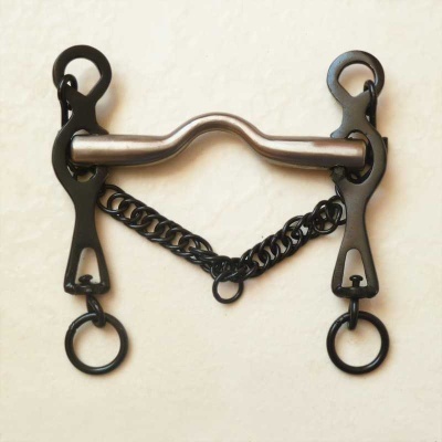 Freio de cavalo metálico com corrente preta sobre fundo creme