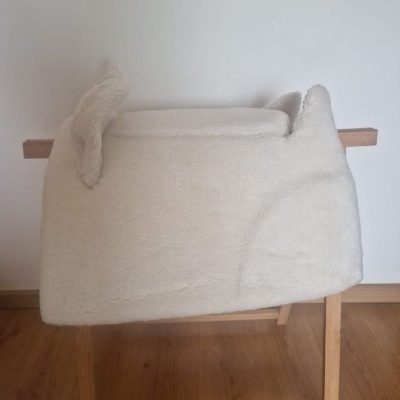 Manta branca peluda sobre estrutura de madeira