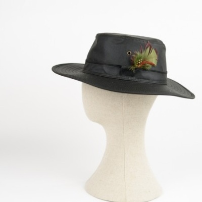 Chapéu preto com asas largas e penas decorativas num manequim bege