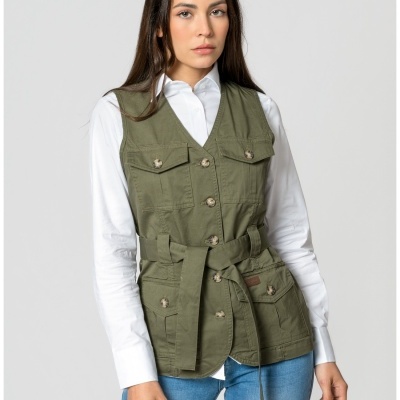 Colete verde caqui com cinto e botões usado sobre camisa branca e jeans azul claro