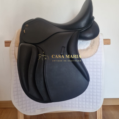 Sela de cavalo preta em couro sobre manta branca e suporte de madeira