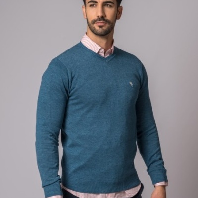 Homem com camisola azul e camisete rosa às riscas