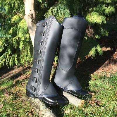 Botas pretas altas com fivelas e costuras em ambiente natural