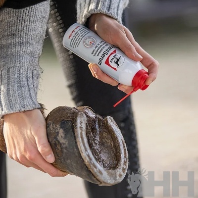 Mãos aplicando spray numa ferradura preta exterior