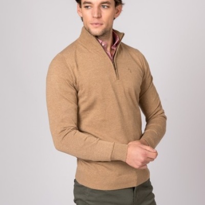 Homem com camisola bege de malha com fecho e calças verdes