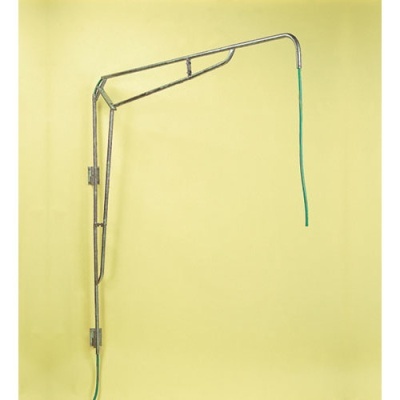 Estrutura metálica suspensa com mangueira verde contra parede amarela