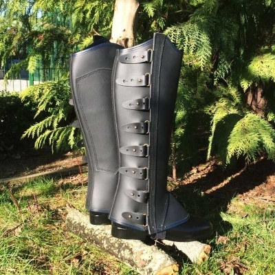 Botas pretas altas de equitação com fechos e fivelas na natureza