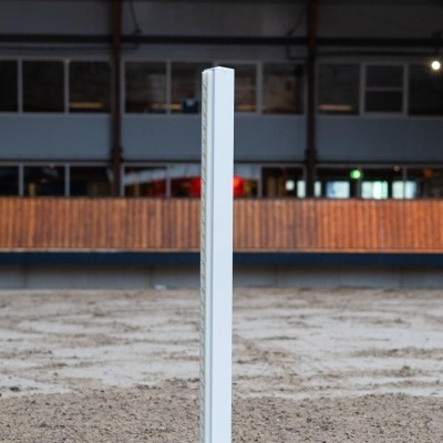 Poste branco com base cinzenta em chão de areia dentro de edifício