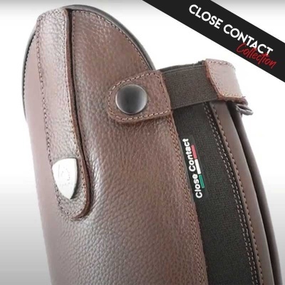 Equipamento de equitação em couro castanho com fecho elástico preto e texto Close Contact Collection