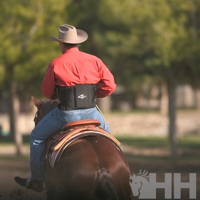 Cavaleiro de costas montado num cavalo com colete preto AFA