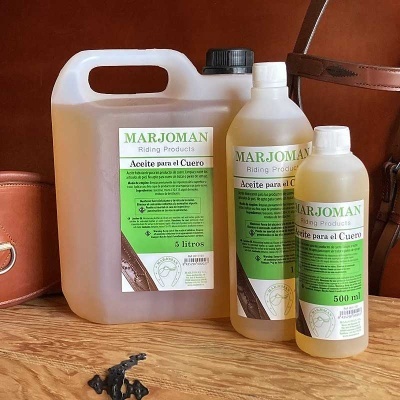 Recipientes de óleo para couro MARJOMAN em plástico translúcido com rótulos verdes e brancos, em três tamanhos, sobre superfície de madeira.