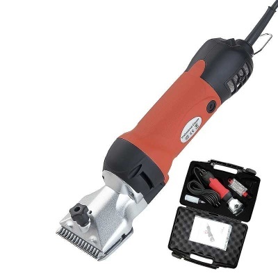 Máquina de tosquiar vermelha com preto, lâminas metálicas e maleta preta com acessórios.