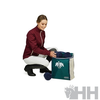 Mala de armazenamento com mantas azuis junto a mulher com casaco vinho e calças branco