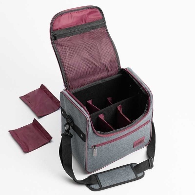 Saco de transporte cinzento com interior vinho e alça preta aberto junto com dois tecidos vinho.