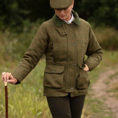 Casaco verde xadrez com botões e bolsos, com boné combinado, em ambiente natural