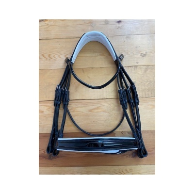 Bridão preto com acolchoado branco sobre piso de madeira