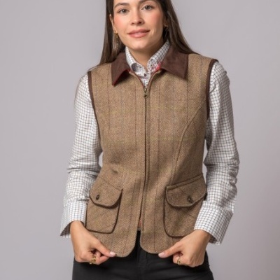 Mulher com colete castanho xadrez e camisa branca de quadrados