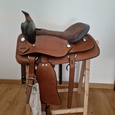 Sela de cavalo de couro castanho com assento acolchoado castanho escuro em suporte de madeira