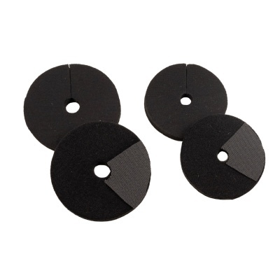 Quatro proteções redondas de espuma preta com orifício central e recorte em material distinto
