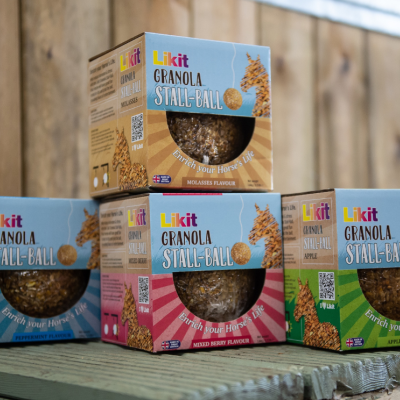 Caixas coloridas de granola Likit para cavalos em prateleira de madeira