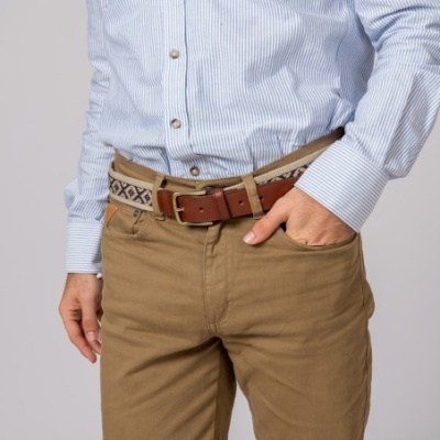 Homem com camisa azul clara de riscas e calças castanhas com cinto castanho e padrão têxtil