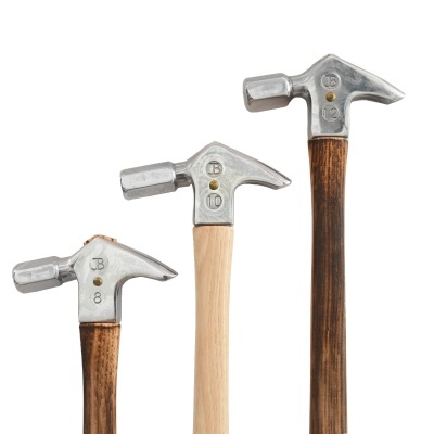 Três martelos com cabeças metálicas e cabos de madeira em fundo branco