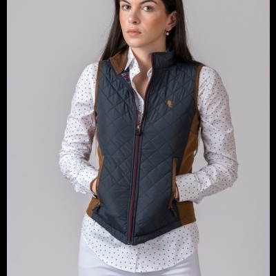 Colete acolchoado preto com detalhes castanhos usado com camisa branca de pontos e calças brancas