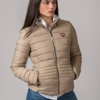 Casaco acolchoado bege com fecho de correr cinzento e emblema de escudo no peito