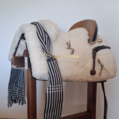 Sela de equitação com almofada branca e assento castanho em suporte de madeira