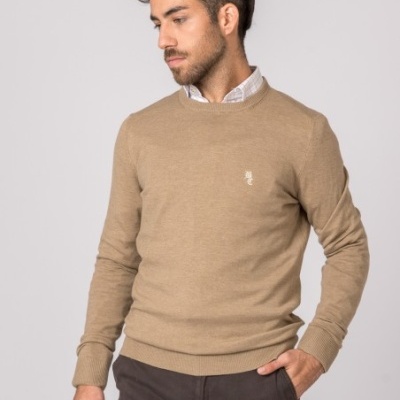 Homem vestido com sweater bege de malha e calças cinzentas