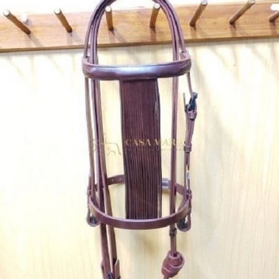 Cabeçada de couro castanha pendurada num cabide de madeira