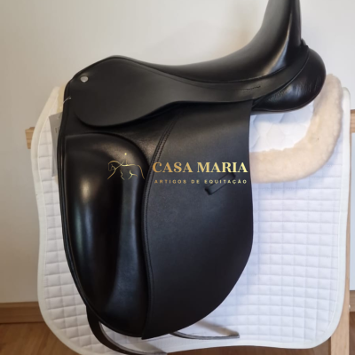 Selim de equitação preto em couro sobre almofada branca acolchoada e suporte de madeira