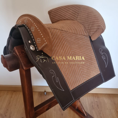 Sela de equitação castanha e bege com detalhes em couro escuro e suporte de madeira