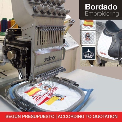 Máquina de bordar Brother a bordar tecido branco com desenhos coloridos.